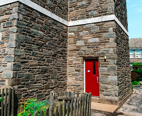 Exterior stone wall on old building with red door